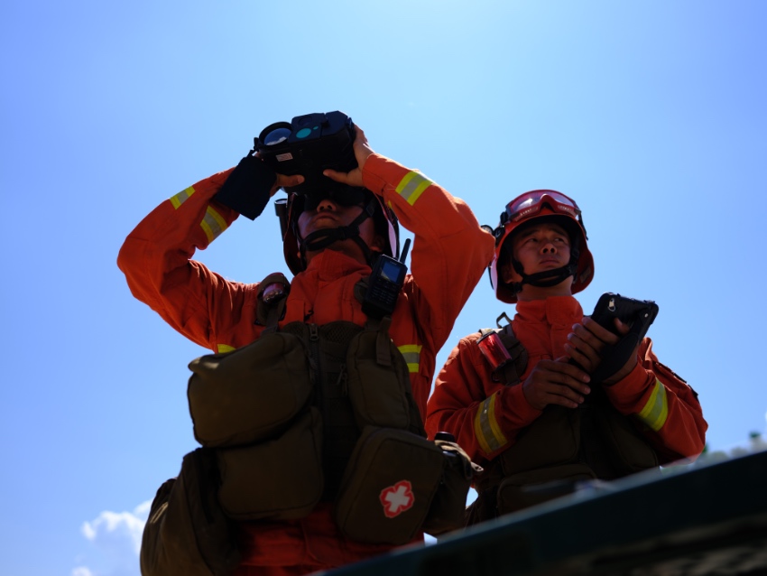消防救援人員用紅外望遠鏡勘察火場。四川省森林消防總隊供圖