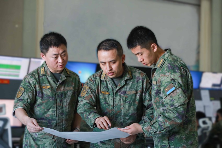 空管保障組成員在一起研究制定飛行管制方案。卜令軍攝