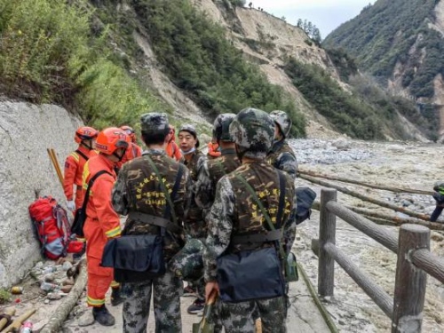 退役軍人志愿者與專業救援隊伍一起進溝開展救援工作，協助消防救援人員搭建救援便橋。四川省退役軍人事務廳供圖