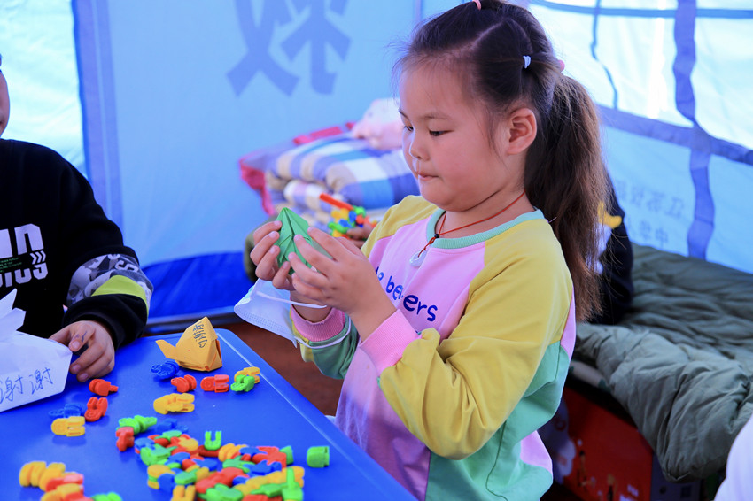 安置點的小朋友正在準備禮物。人民網 朱虹攝