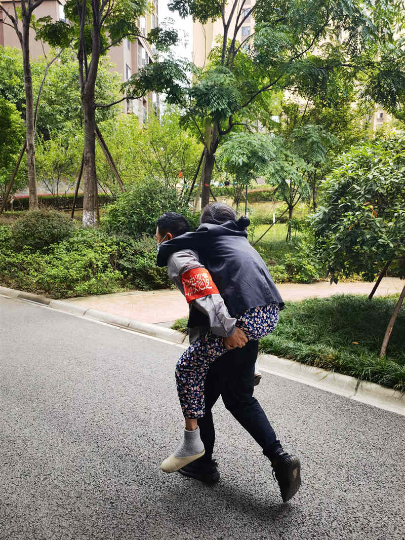 錦和康城和貴苑小區內成都交子金控志愿者黃林背起暈倒的老人一路小跑送醫。成都市國資委供圖