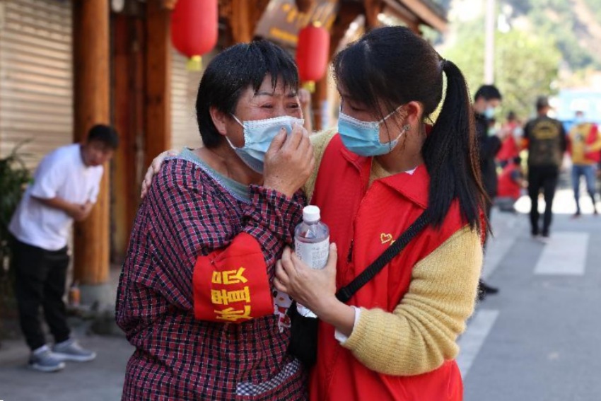 客戶經理王莉安慰磨西鎮杉樹商店老板張惠蘭。劉景攝