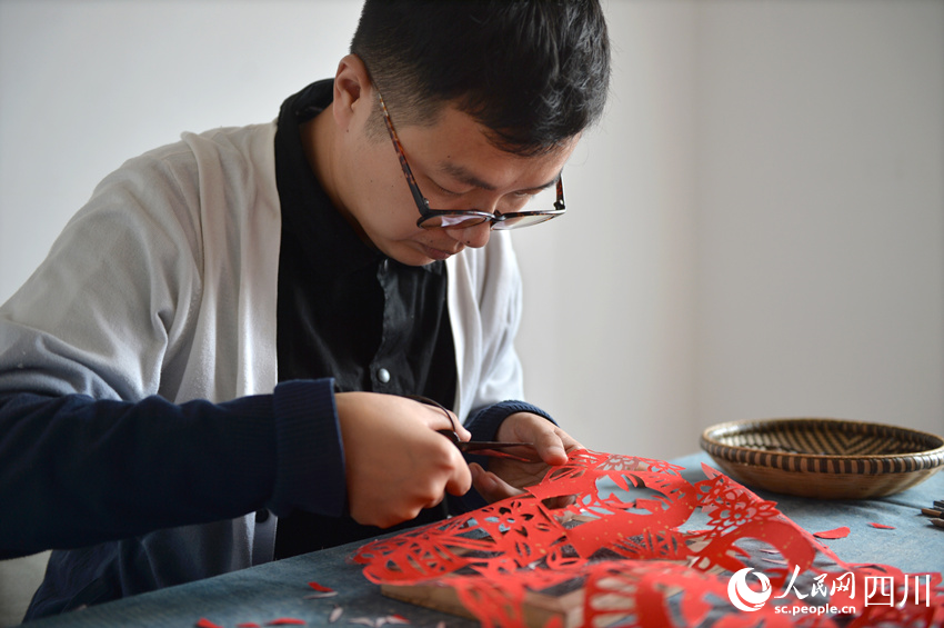 李有生在創作剪紙。王斌攝