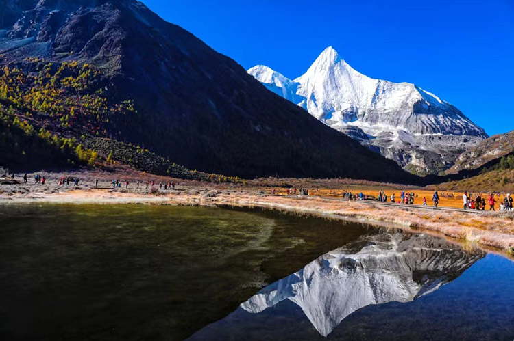 游人在景區內欣賞美景。稻城亞丁景區供圖