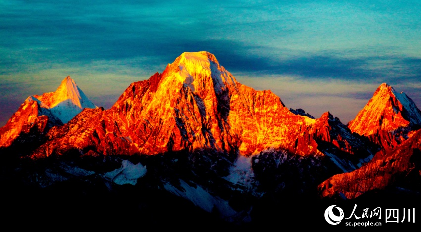 在瑪娜茶金觀景平臺，可近觀仙乃日、央邁勇、恰朗多吉三座雪山，極其壯觀。圖為日照金山景象。陳進攝