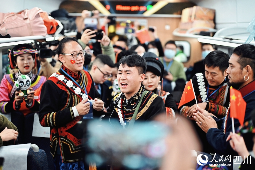 車廂內彝族同胞載歌載舞，氣氛熱烈。李富彬攝