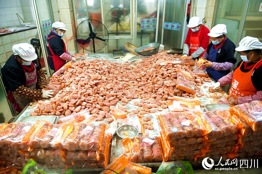 當地村民在車間內包裝橘餅蜜餞。黃正華攝