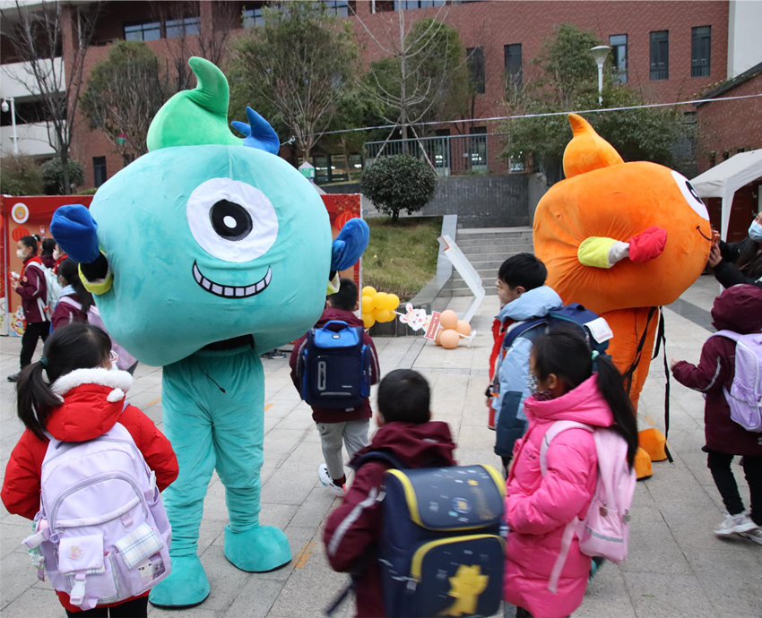 孩子們與吉祥物“六仔六妹”握手互動。四川省天府新區第六小學供圖