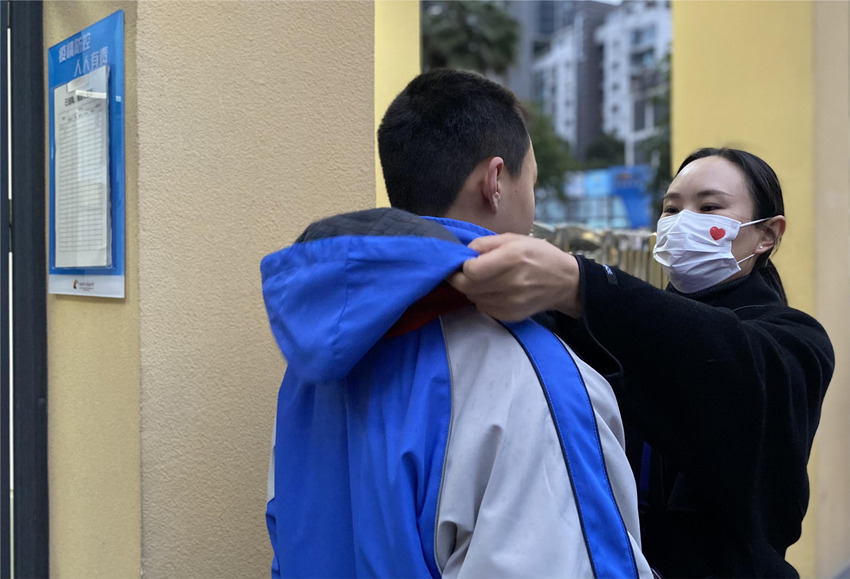新學期老師在為剛入校的同學整理衣服。成都市青羊實驗中學供圖