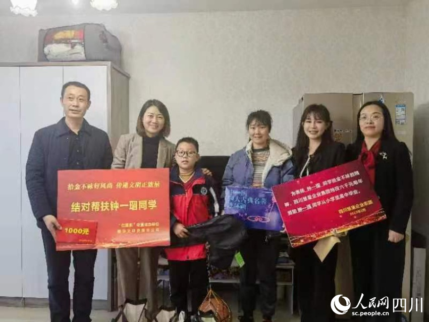 圖為愛心人士為鐘一瑁送去助學“大禮包”。劉佳雨攝