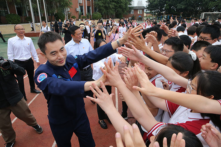 同學們和葉光富熱情打招呼。天府新區融媒體中心供圖