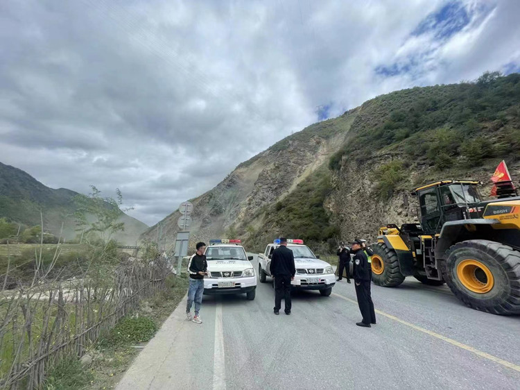 警察現場執勤，施工隊正在排險。松潘縣融媒體中心供圖