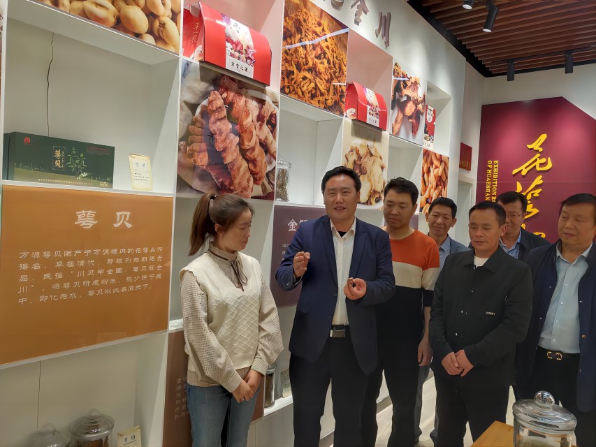 項家坪村支部書記龔代禮（左二）正在講述萼貝故事。達州市中醫藥管理局供圖