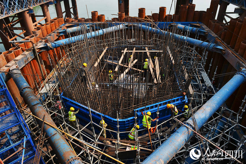 工人們在主橋墩身綁扎鋼筋和安裝模板。王斌攝