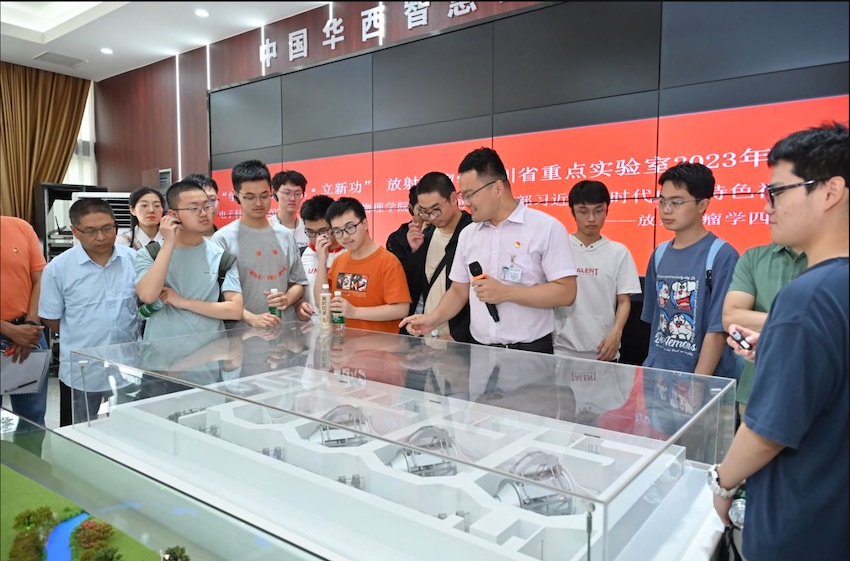 王先良向學生講解質子治療的原理和設備。受訪者供圖