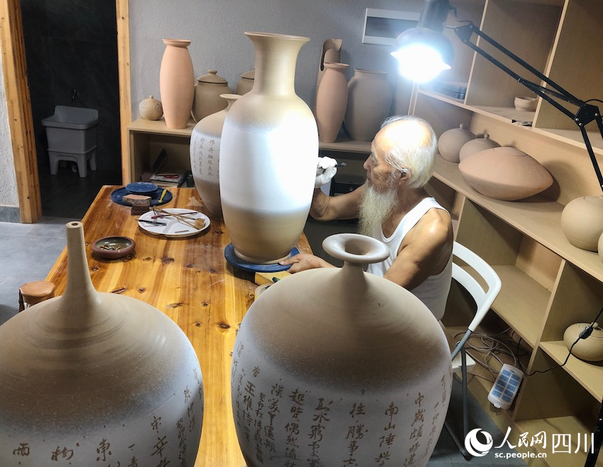 工匠正在陶器上刻字。鄧蕓攝