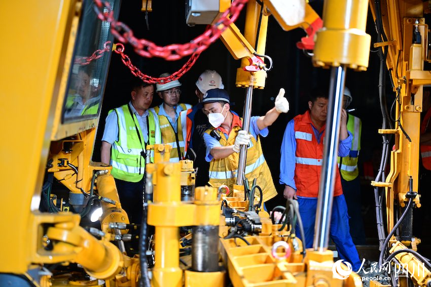 鐵路工人正在指揮一號位進行道岔搗固。齊亮攝