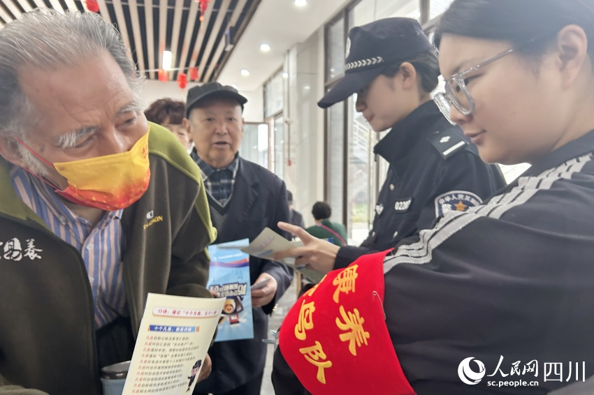 “康養候鳥隊”隊員為老人送上反詐宣傳資料。人民網記者 李平攝