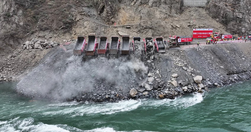 數輛自卸車將成噸的石料拋投進主河床龍口。雅礱江公司供圖