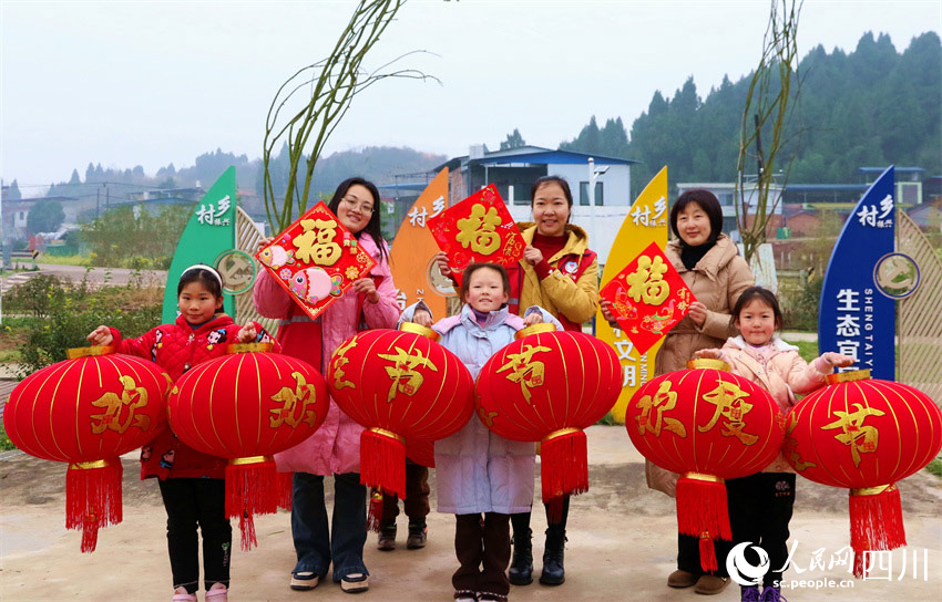 黨員志愿者和小朋友一同展示燈籠和福字。潘建勇攝