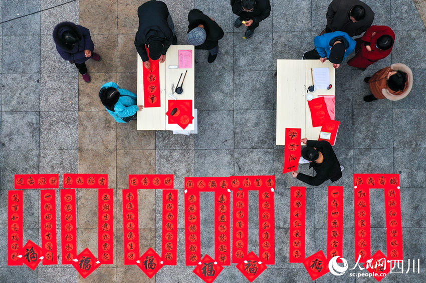 文化志愿者為群眾免費寫春聯。牟科攝