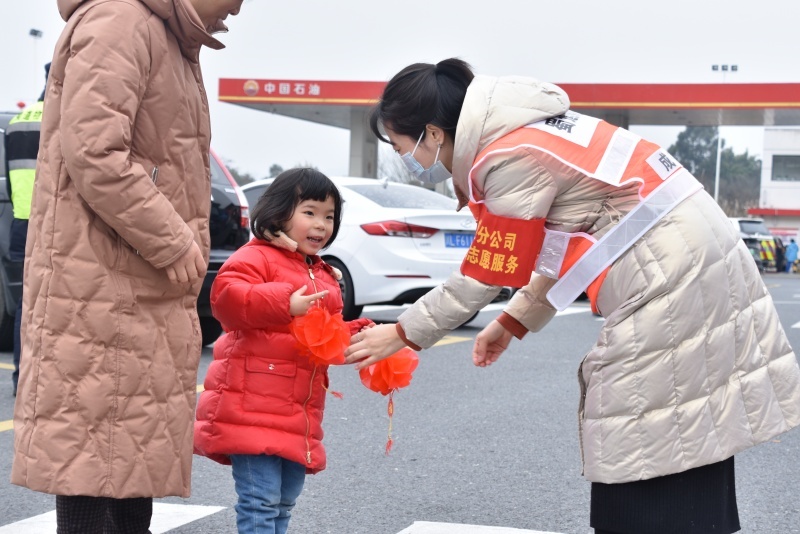 蜀道集團成渝公司成仁高速永興服務區志愿服務者向司乘朋友贈送禮品掛件。蜀道集團供圖