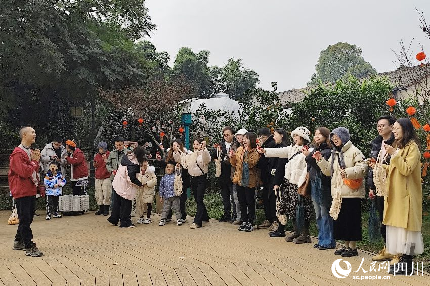 葉科（左一）給前來參與活動的“柑爸柑媽”介紹生態種植果。人民網記者朱虹攝