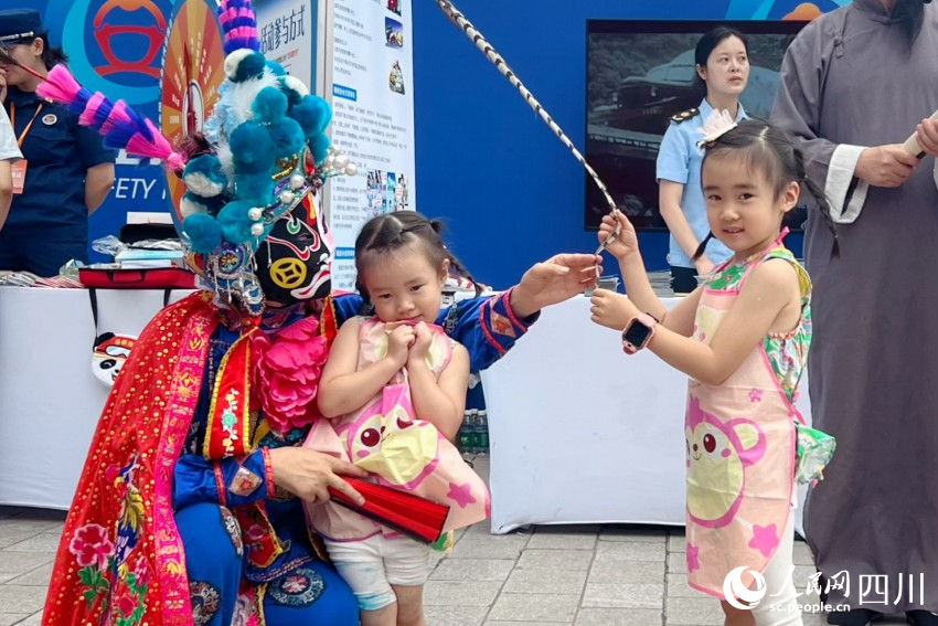 活動現場的川劇表演人員與小朋友互動。人民網 趙祖樂攝