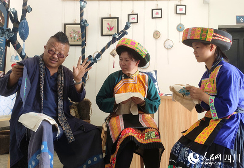 楊安平在講解蠟染技藝。曾剛攝