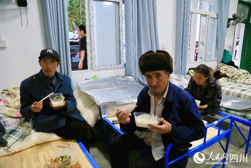 7月21日晚7點，漢源縣馬烈鄉新華小學安置點的村民正在吃晚餐。人民網記者 朱虹攝