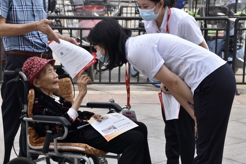 在都江堰市開展長護險進社區宣傳 經辦人員對社區老年人失能情況進行詢問（2023年9月8日）。都江堰市醫療保障局供圖