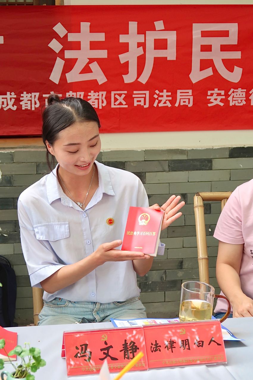 成都市“‘典’進鄉村 法護民企”民法典宣傳月活動現場，法律明白人為群眾介紹《民法典百問百答》讀本。成都市司法局供圖