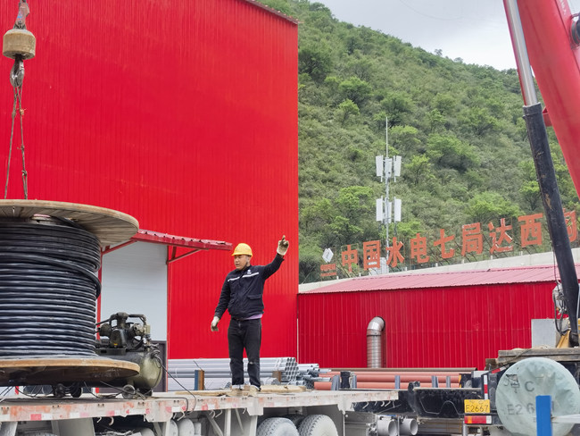 來自甘孜的洛絨達吉在家鄉水電站項目上指揮吊車裝卸電纜。水電七局供圖