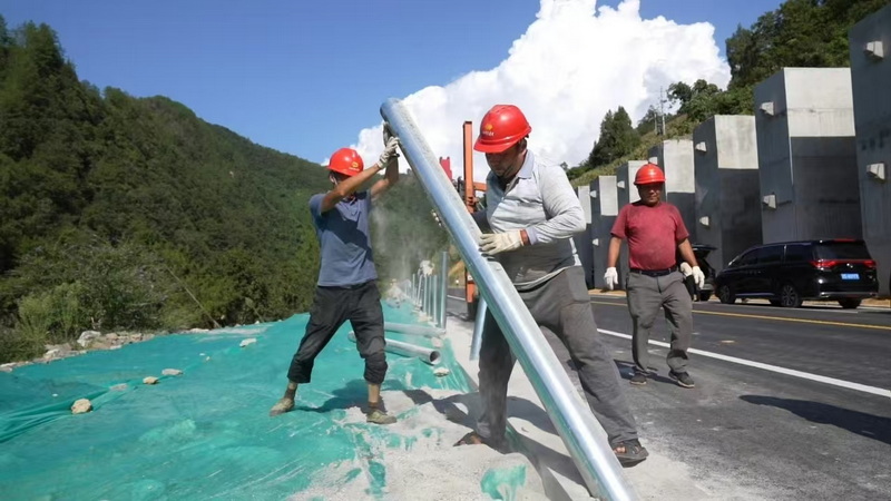 安裝波型護欄。萬源市融媒體中心供圖