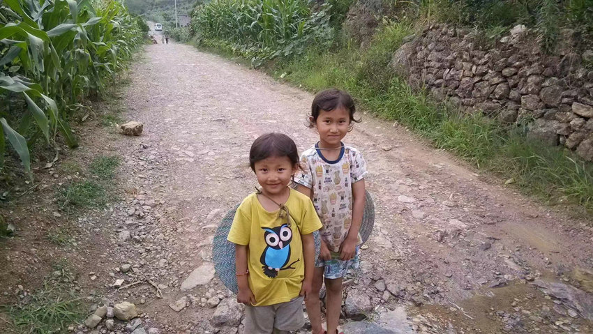 10年前，羅馨怡和妹妹羅思柳站在泥結碎石路上的合影。受訪者供圖