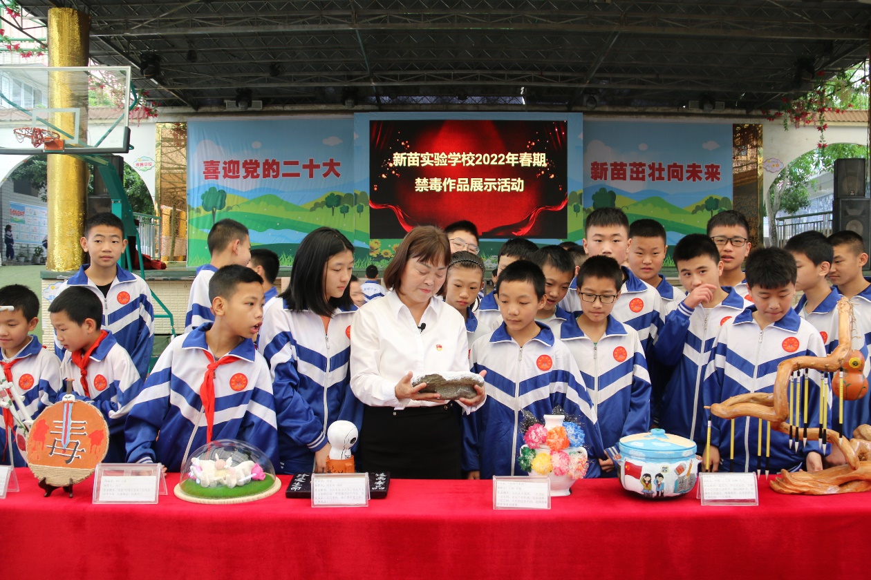 李修會與孩子們參加禁毒作品展示活動。敘永縣摩尼鎮新苗實驗學校供圖