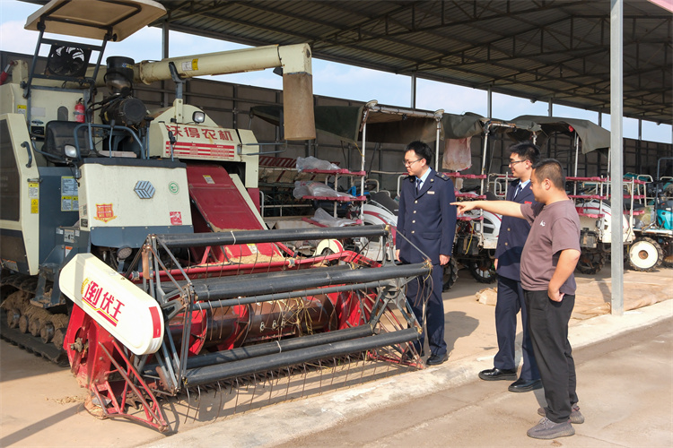 金穗源糧食專業合作社負責人向稅務干部介紹農機設備。四川省稅務局供圖