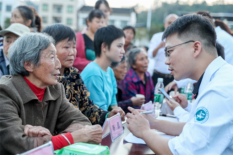 志愿者在高興鎮花廟嘴村文體廣場，為村民講解衛生與健康知識。邱海鷹、劉南賢供圖