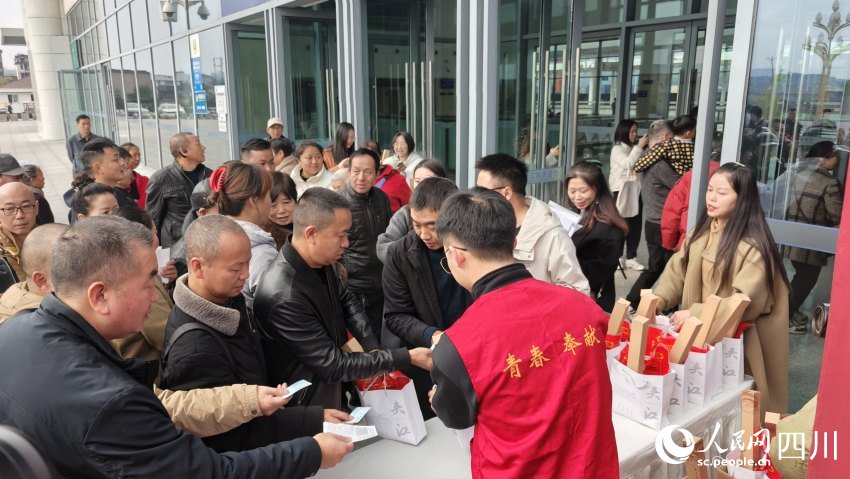 乘坐夾江站首發列車的旅客領取宣傳品。陳萱攝