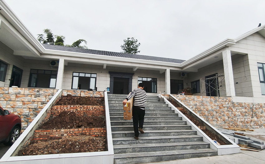 溫俊偉在搬運新房用的家電。陳萱攝