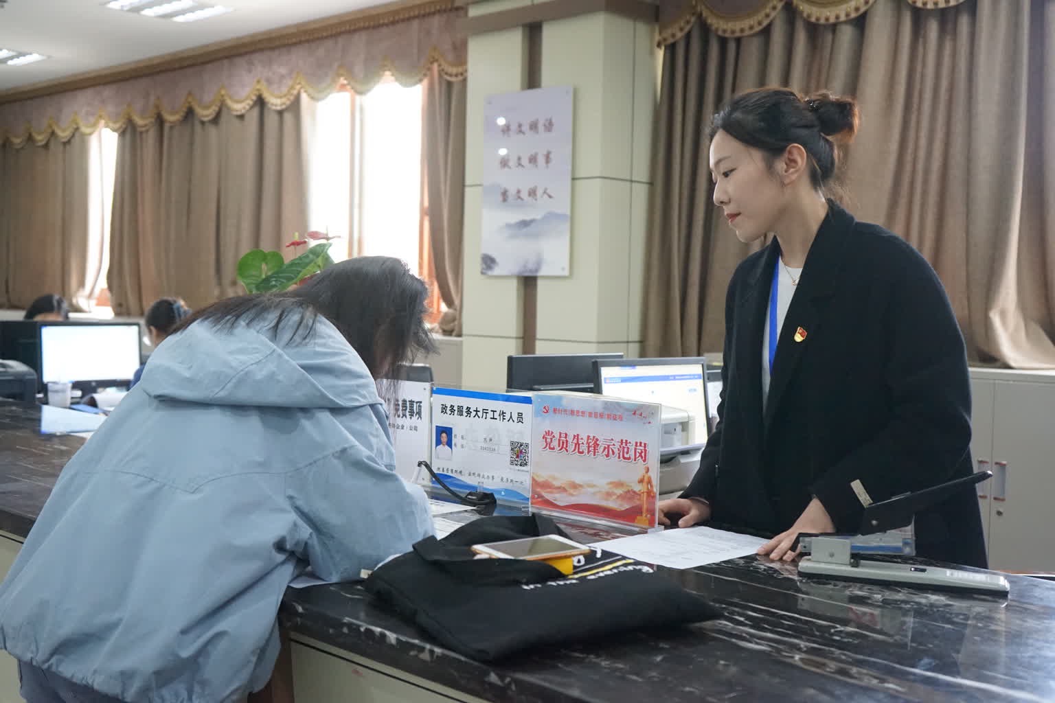 在高坪區行政審批辦事大廳，工作人員正在指導申辦人填寫表格。高坪區融媒體中心供圖