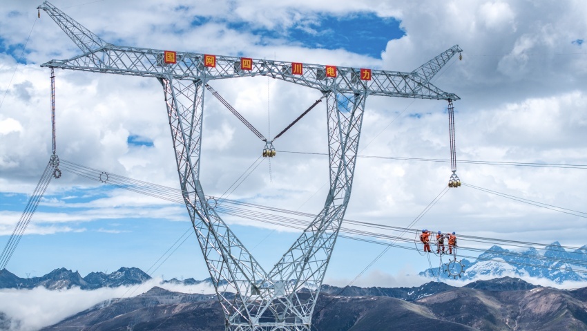 2024年6月3日，川渝特高壓工程1000千伏輸電線路飛越折多山，在70米高空，國網四川電力施工人員配合安裝間隔棒及其附件。陳欣攝