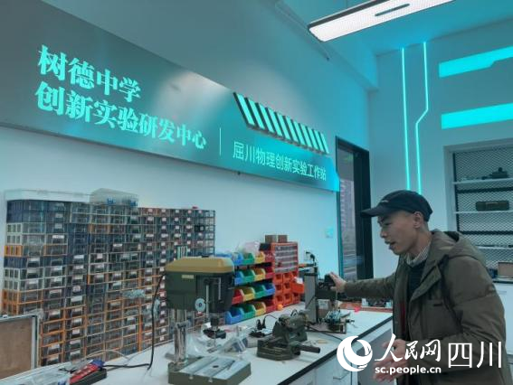 屈川向記者介紹工作站的建設情況。張欣宜攝