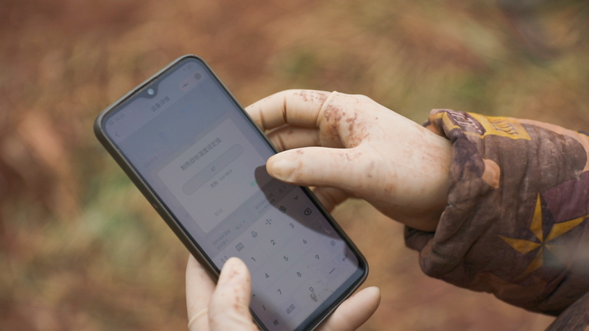 游俊剛用手機操作鍋爐設備。謝金成攝