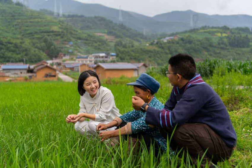 鄧小燕（左）與村民在田間交流。受訪者供圖
