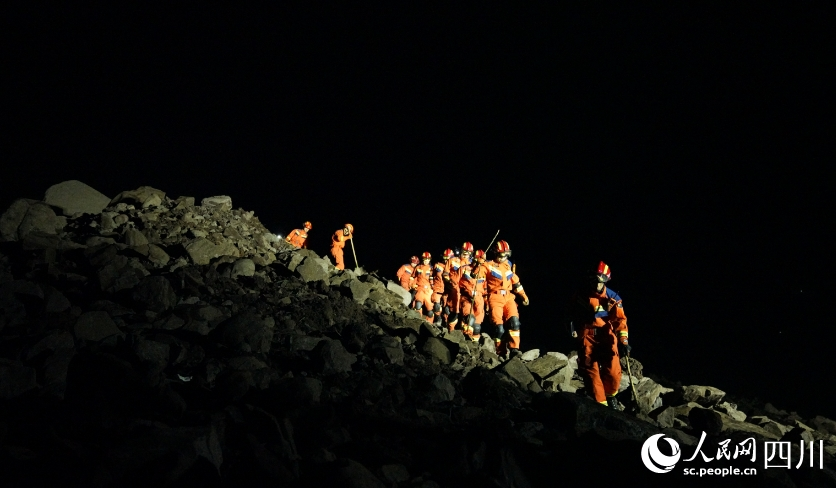 夜深，消防人員依然行進在搜救路上。宋豪新、黃超攝