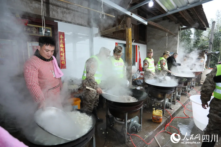 “臨時廚房”里，救援隊伍與村民一同制作飯菜。鄭鵬攝