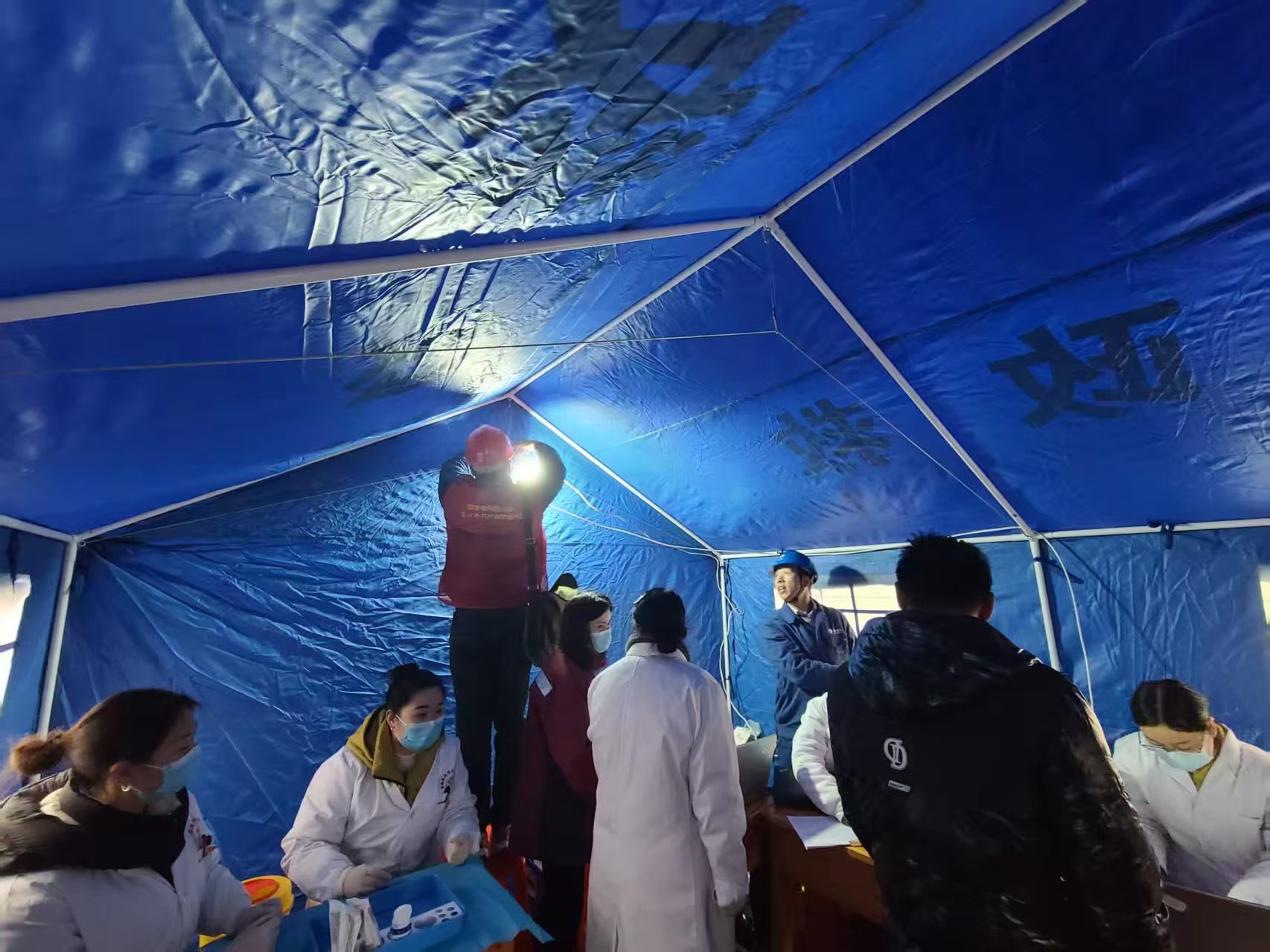 在受災群眾安置點，國網宜賓供電公司搶險支援人員第一時間為紅十字會救災帳篷安裝照明燈。楊義偉攝