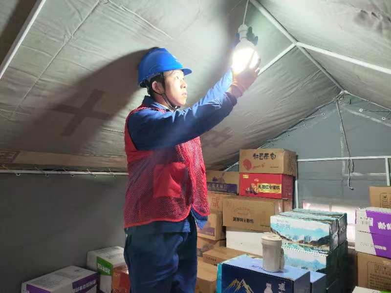 在受災群眾安置點，國網宜賓供電公司搶險支援人員第一時間為紅十字會救災帳篷安裝照明燈。楊義偉攝