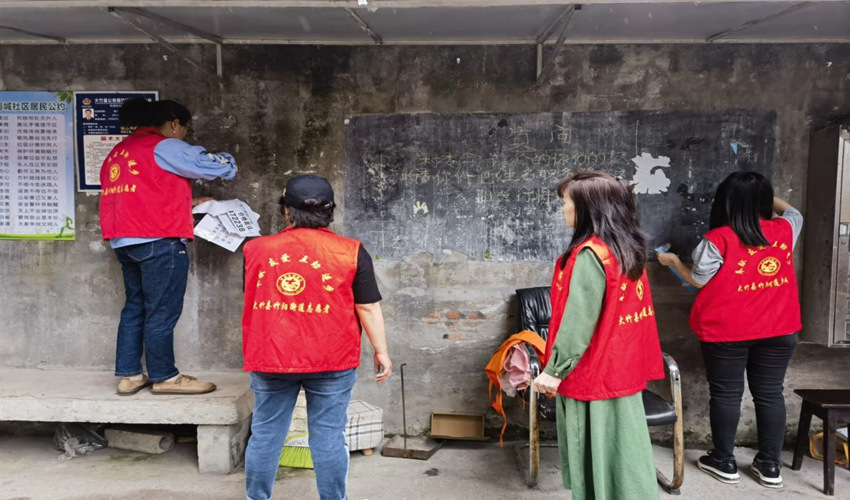 南城社區志愿者在清除墻上的“牛皮癬”。受訪者供圖